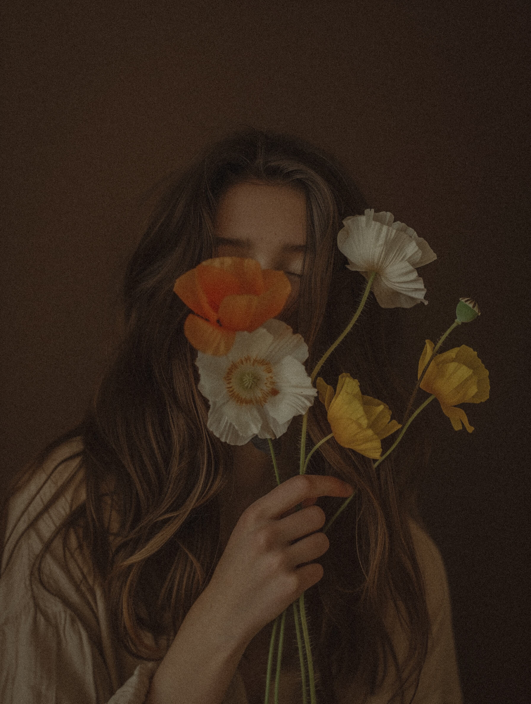 Woman holding fresh flowers in front of her face signifying recovering from burnout